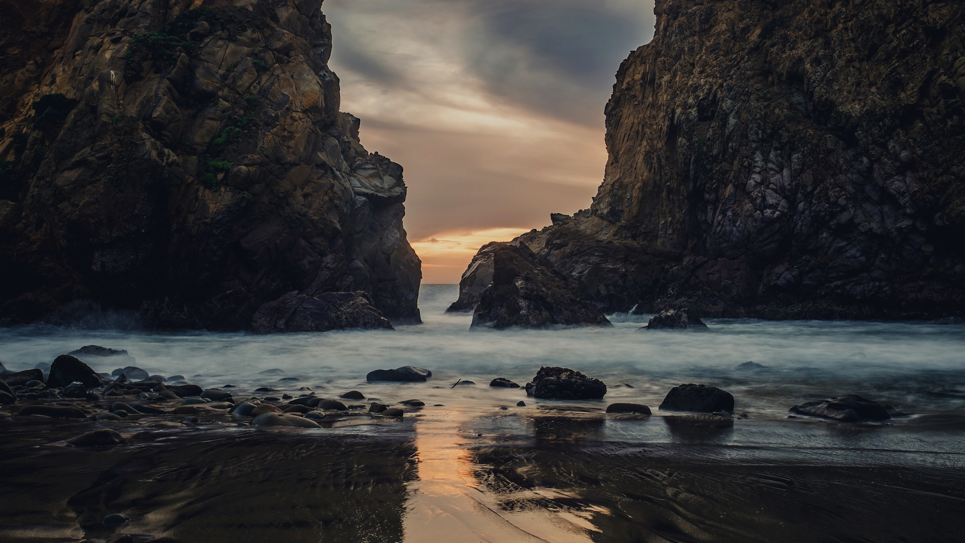 大西洋岸边的海蚀柱峡湾，长曝光下的落日与湿沙滩